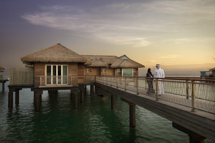 Banana Island Resort Doha By Anantara Exterior View Over Water Villas Couple On Boardwalk